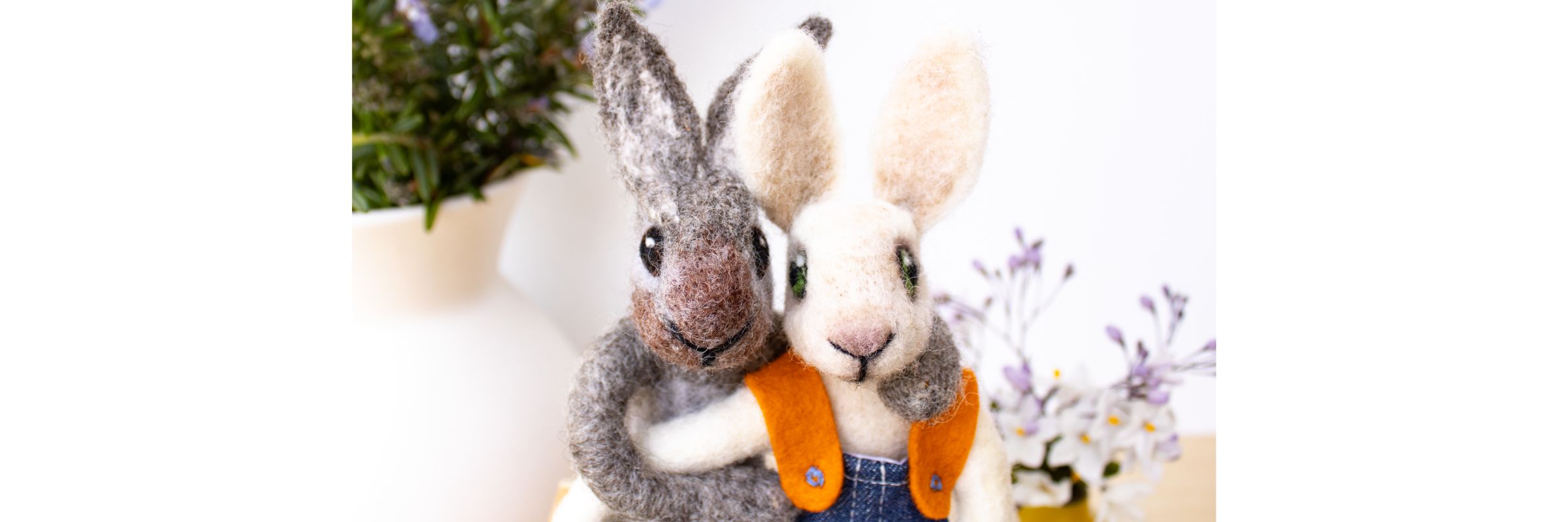 2 hand felted bunnies with their arms around each other